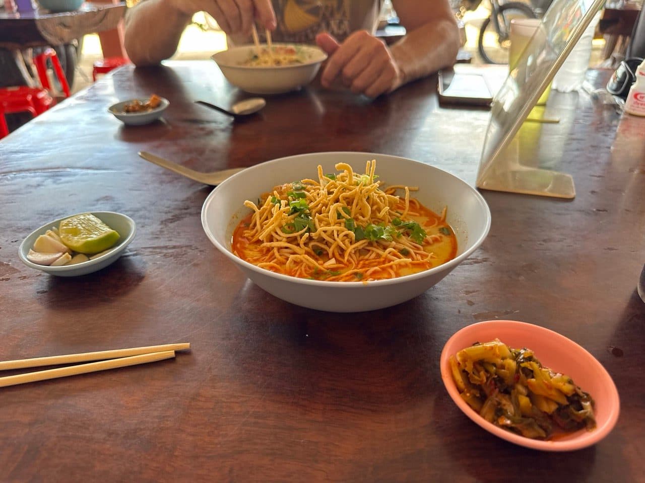 Khao soi with pickled greens and lime.
