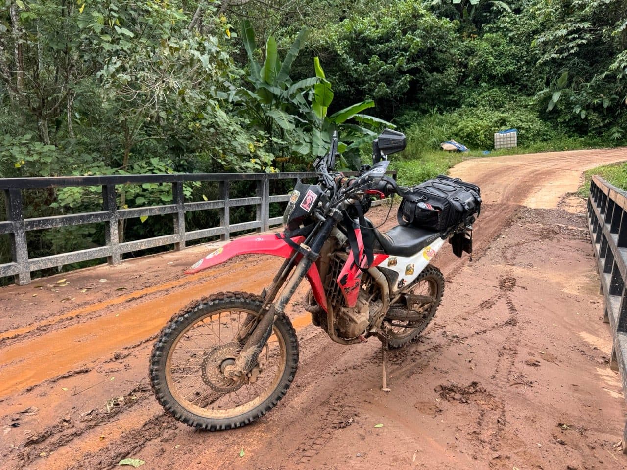 The bike on the concrete bridge, knobbies packed with clay.