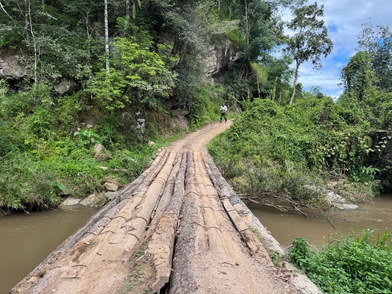 Logs lashed across the river below the rock face